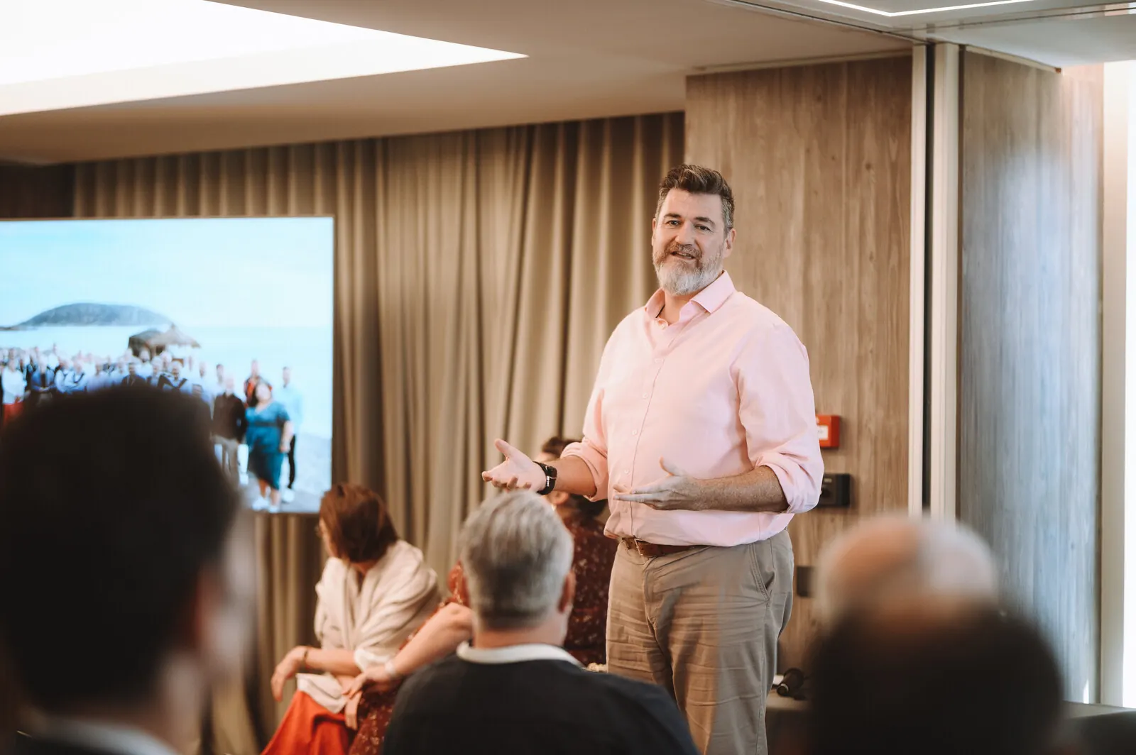 Tony Wood standing and speaking to a seated group during a workshop discussion.