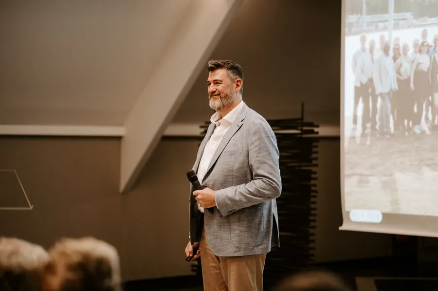 Tony Wood standing beside a projected slide during a talk.